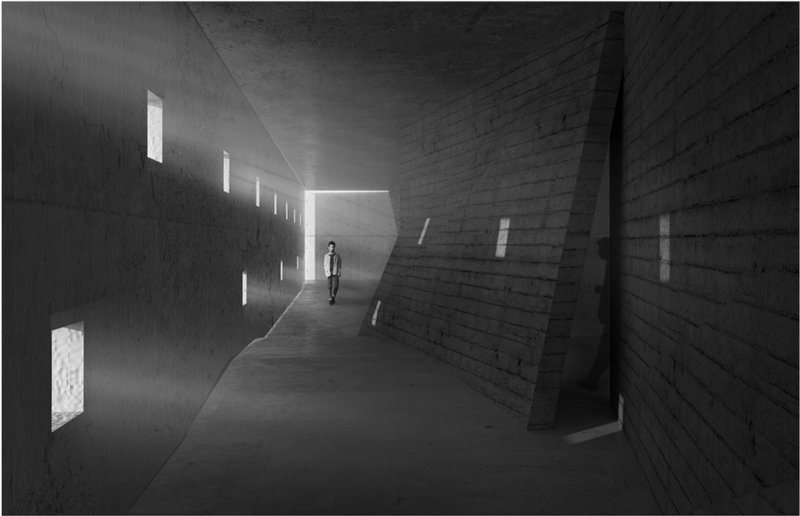 Angled concrete corridor with vertical window slits and a visitor walking through shafts of daylight