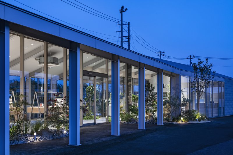 Exterior colonnade with white painted columns and interior courtyard plantings visible at twilight