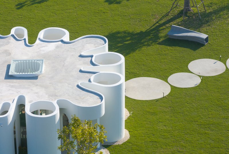 Overhead view showing the scalloped roof edge and circular concrete pads in the lawn