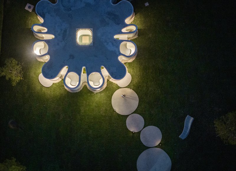 Drone view of the cloverleaf-shaped structure with circular terrace pads at dusk