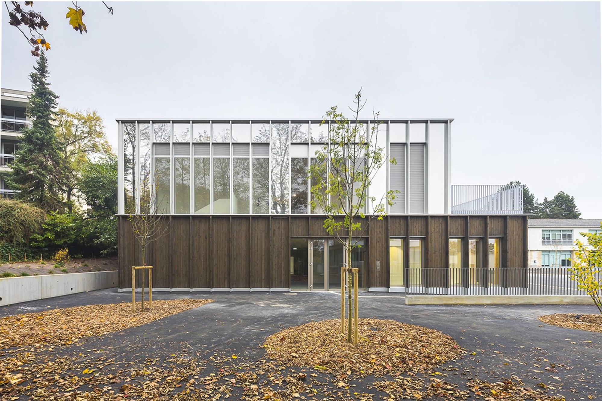 HEMAA Architectes Wraps a School in Mirrored Aluminum and Douglas Fir on a Hilltop Near Paris