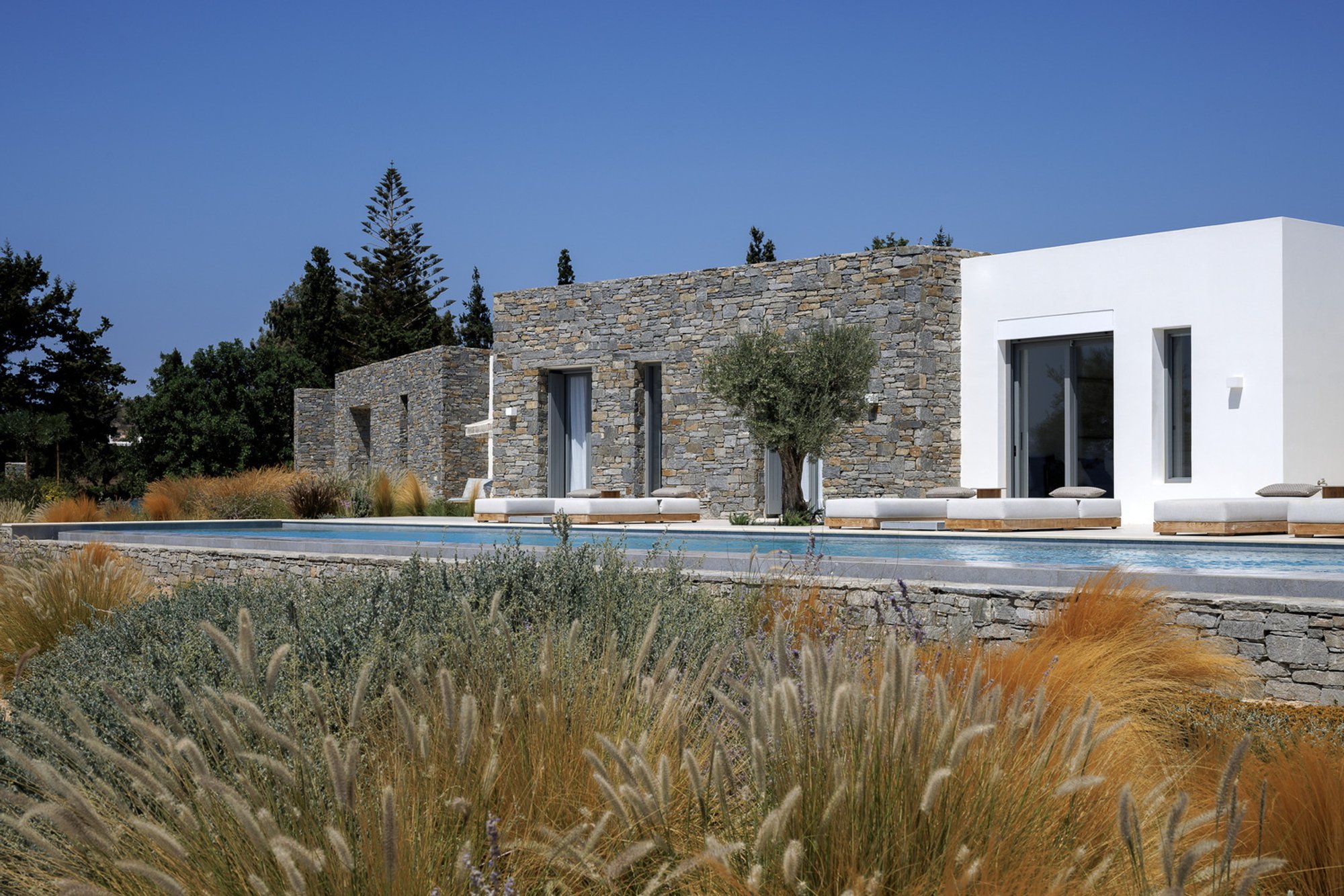 REACT Architects Weave Dry Stone Walls and White Volumes into a Cycladic Compound on Paros