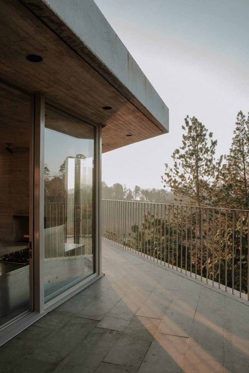 Covered terrace with timber soffit and sliding glass door opening to vertical rod railing