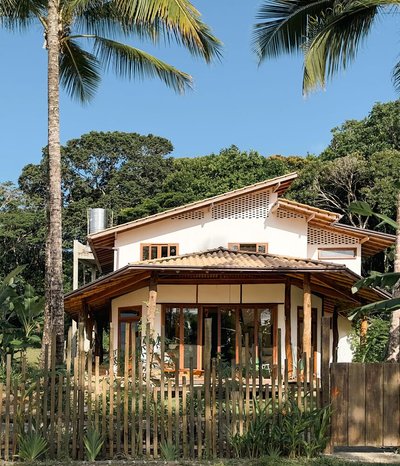 This architectural image showcases a modern tropical house with a focus on natural materials and sus