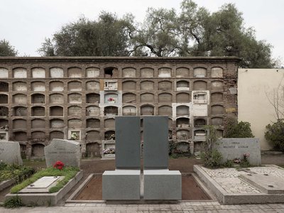 This architectural image showcases a cemetery with a mausoleum wall featuring multiple crypts. The f