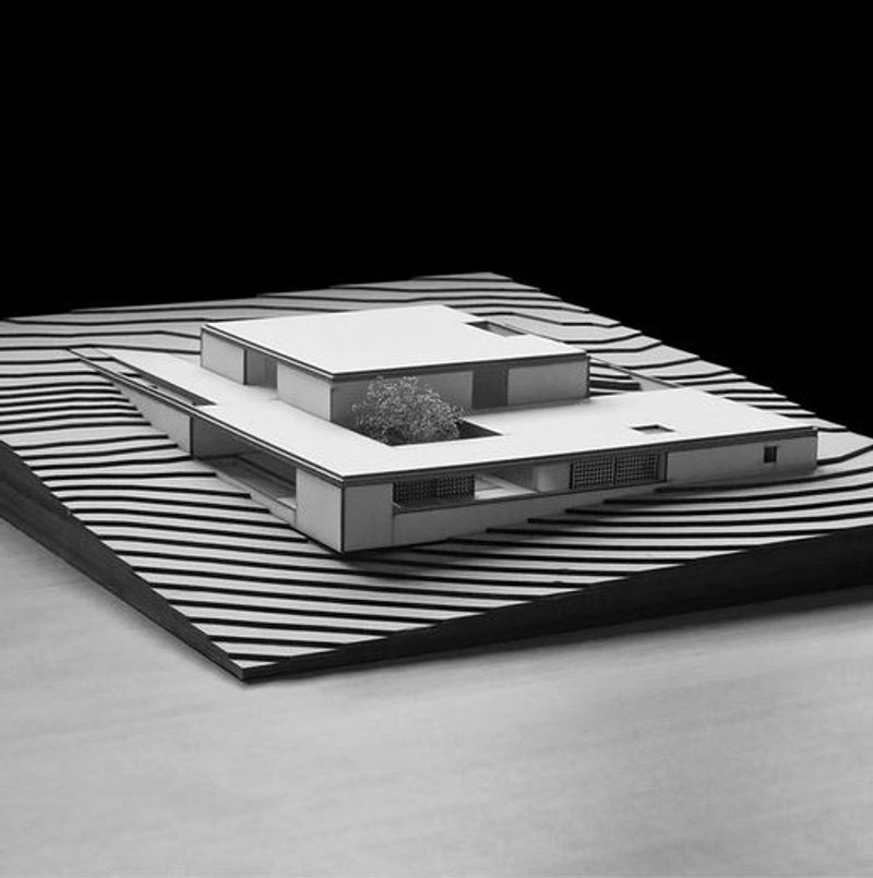 Architectural model showcasing sleek, modern design on terraced landscape.