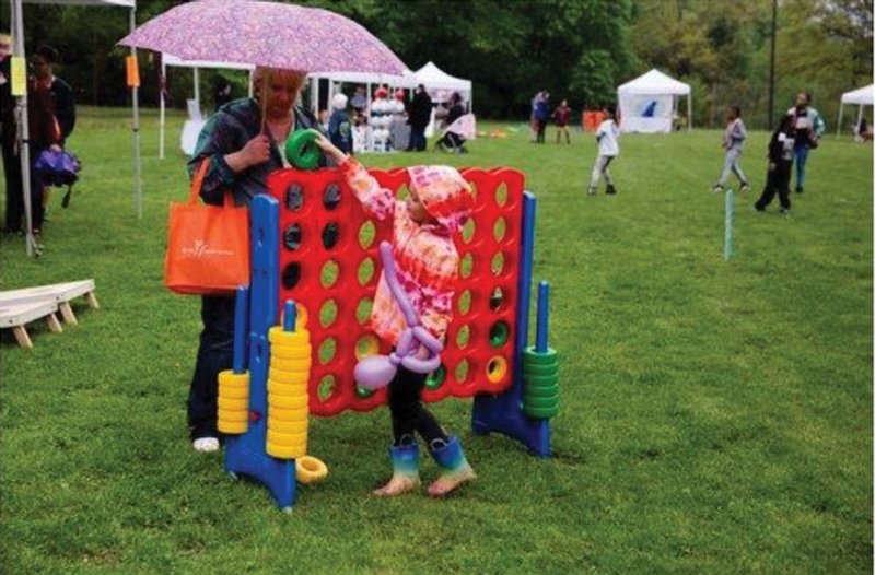 Outdoor fun: Child plays giant Connect Four at a park.