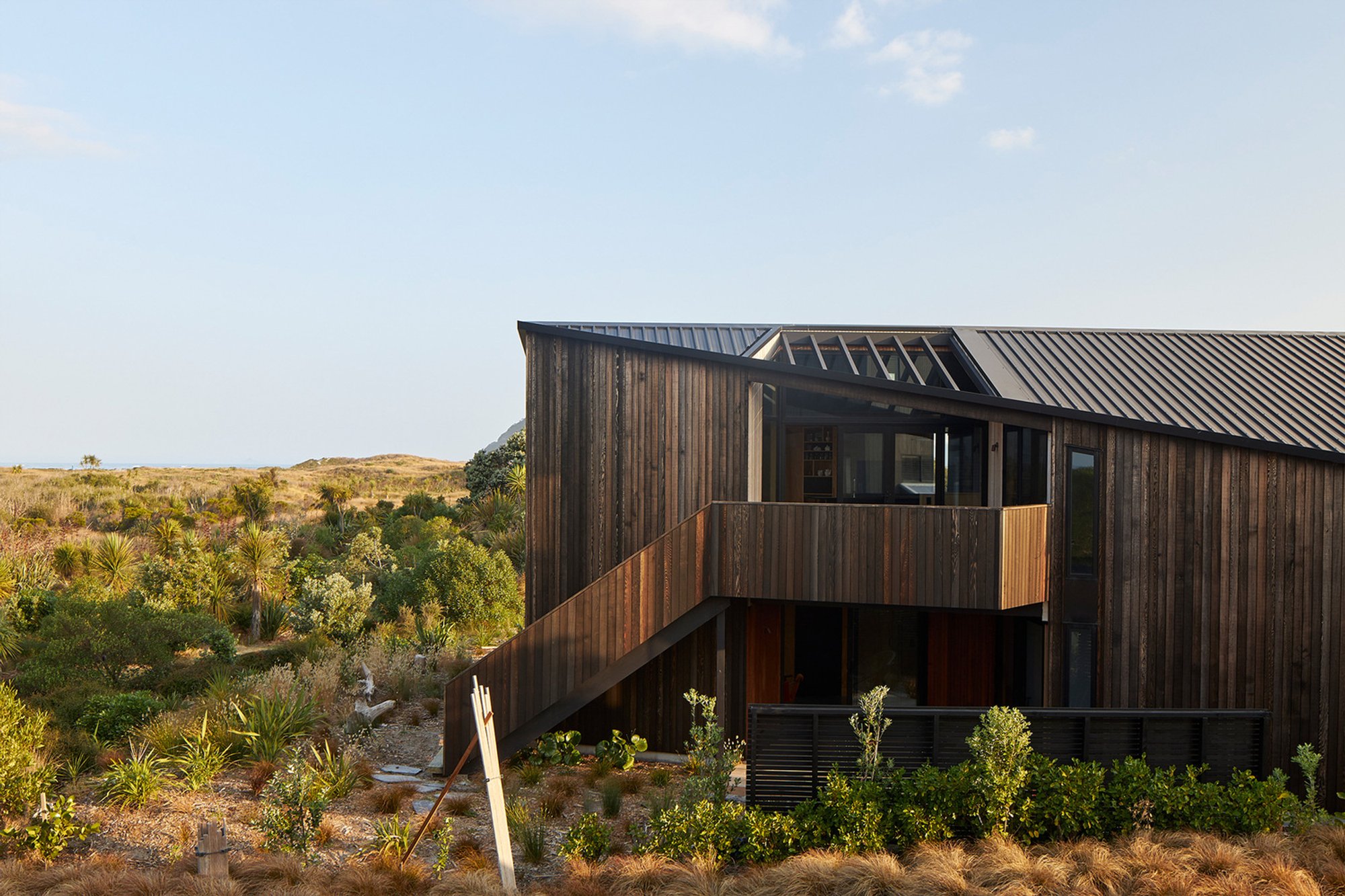 Bowentown Bach House by Edwards White Architects: A Charred Driftwood-Inspired Retreat Along New Zealand’s Rugged Coastline
