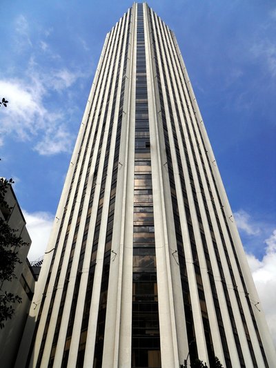 This architectural image showcases a tall skyscraper with a distinctive design. The building feature