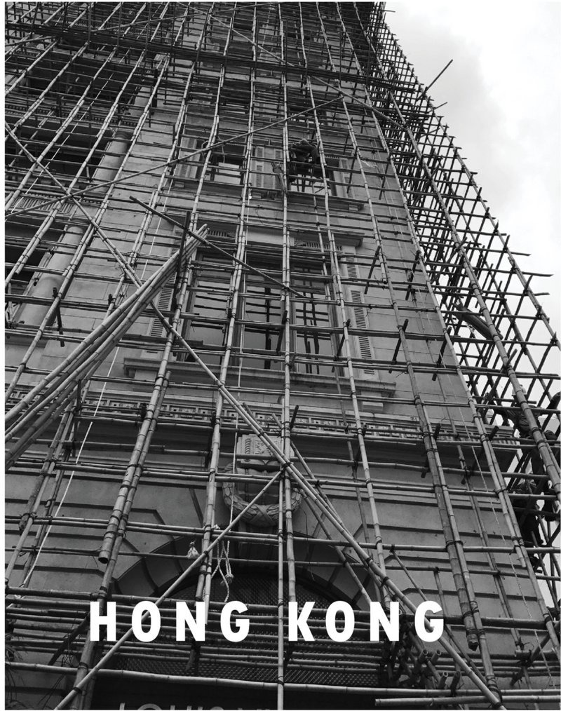 Dense vertical scaffolding redefines the urban facade, making construction a visible city layer.