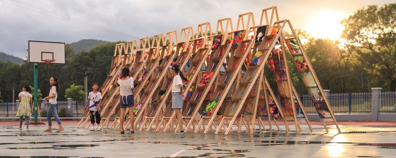 Children engaging in creative play and design with the vibrant wooden ladder pavilion built as part of the Hi Ladders High project.