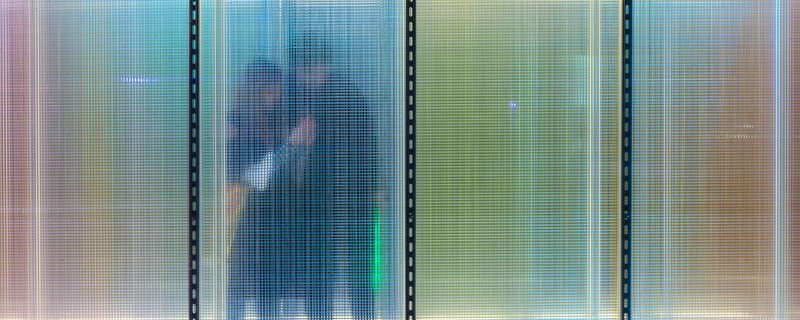 The interplay of light and texture creates a blurred boundary between the physical space and those within it, offering a unique visual experience.