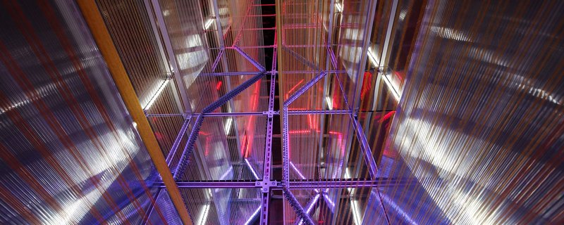 A captivating view of light and structure intertwining in an architectural installation, where colors and angles create dynamic visual effects.