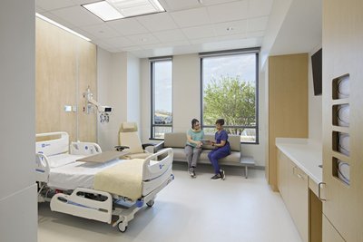 This architectural image showcases a modern hospital room designed for patient comfort and efficient