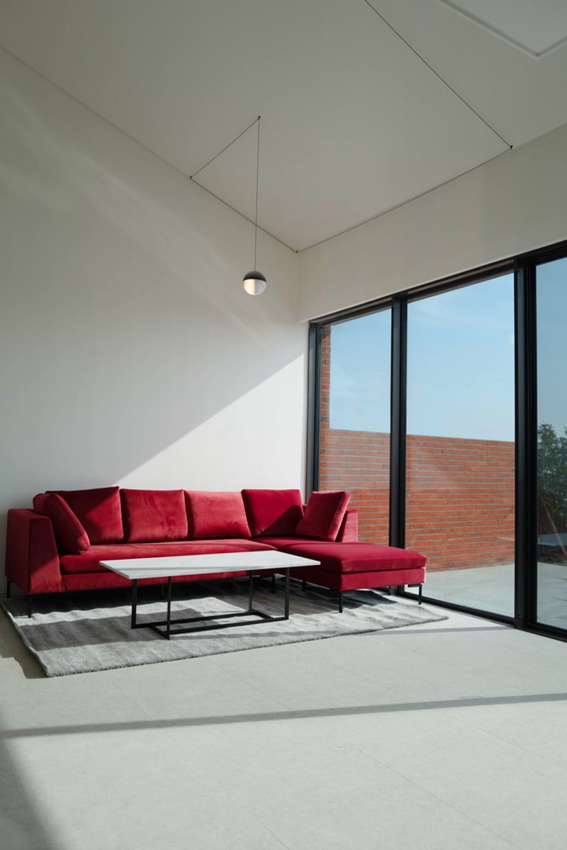 Interior corner with afternoon sunlight entering through the floor-to-ceiling glazed doors