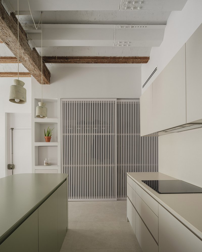 Kitchen passage with ribbed sliding panels, exposed timber beams, and open shelving with a potted plant