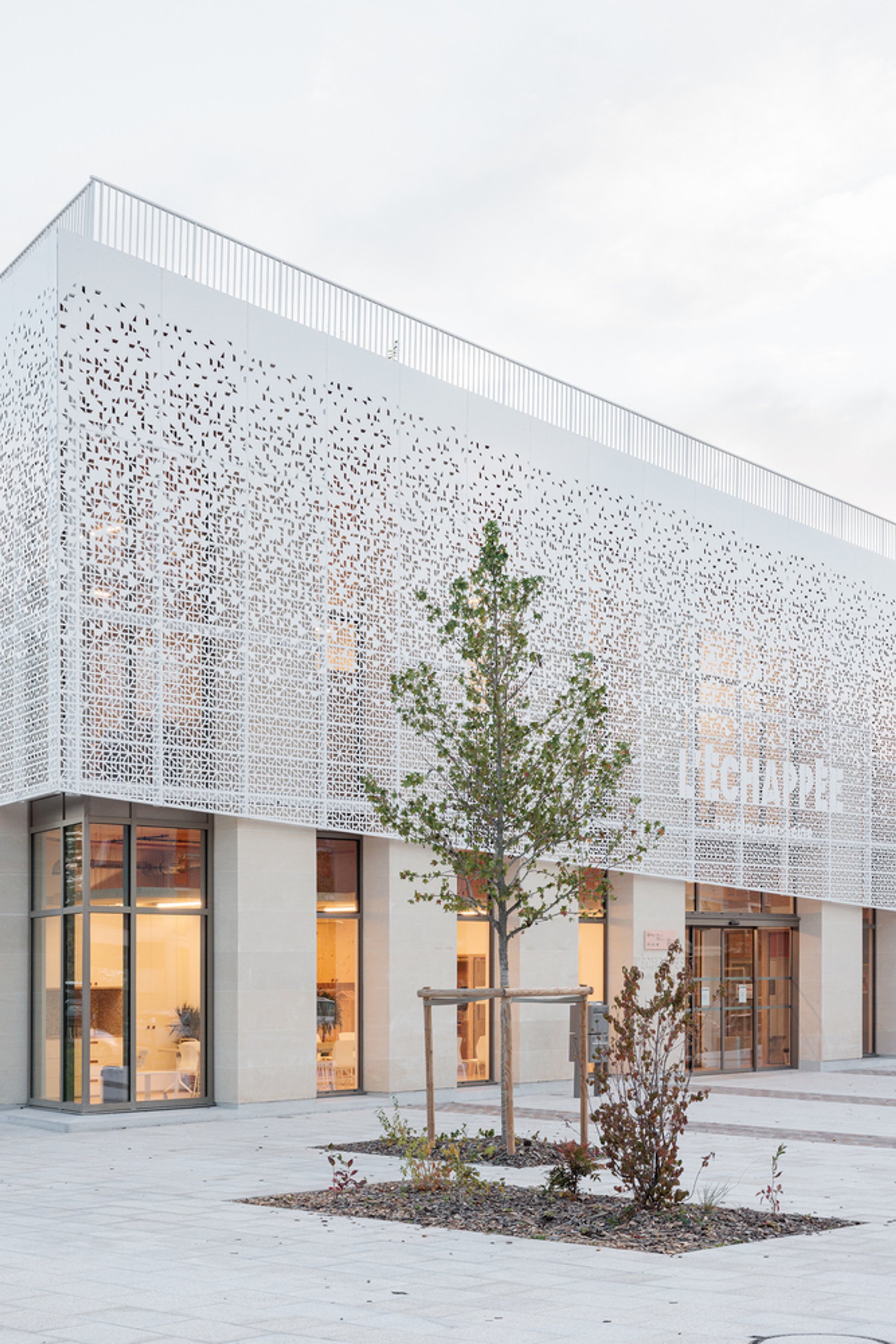 Atelier WOA Wraps a Timber and Stone Library in a Perforated Veil at Herblay-sur-Seine