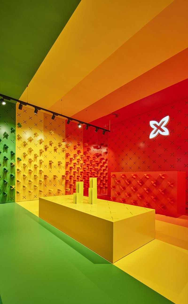 Long view of retail display counter under gradient ceiling with modular wall shelving and track lighting