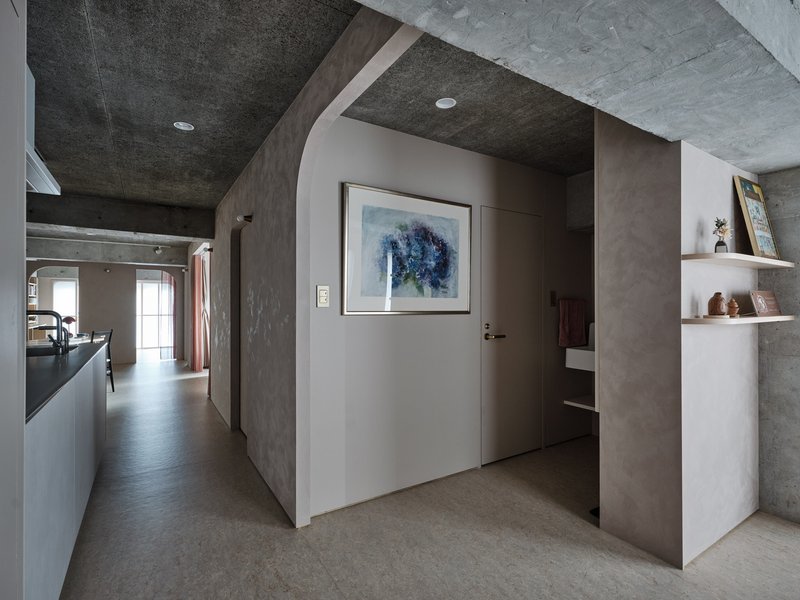 Entry corridor with white niche, painted ceiling vaults and artwork beside a doorway