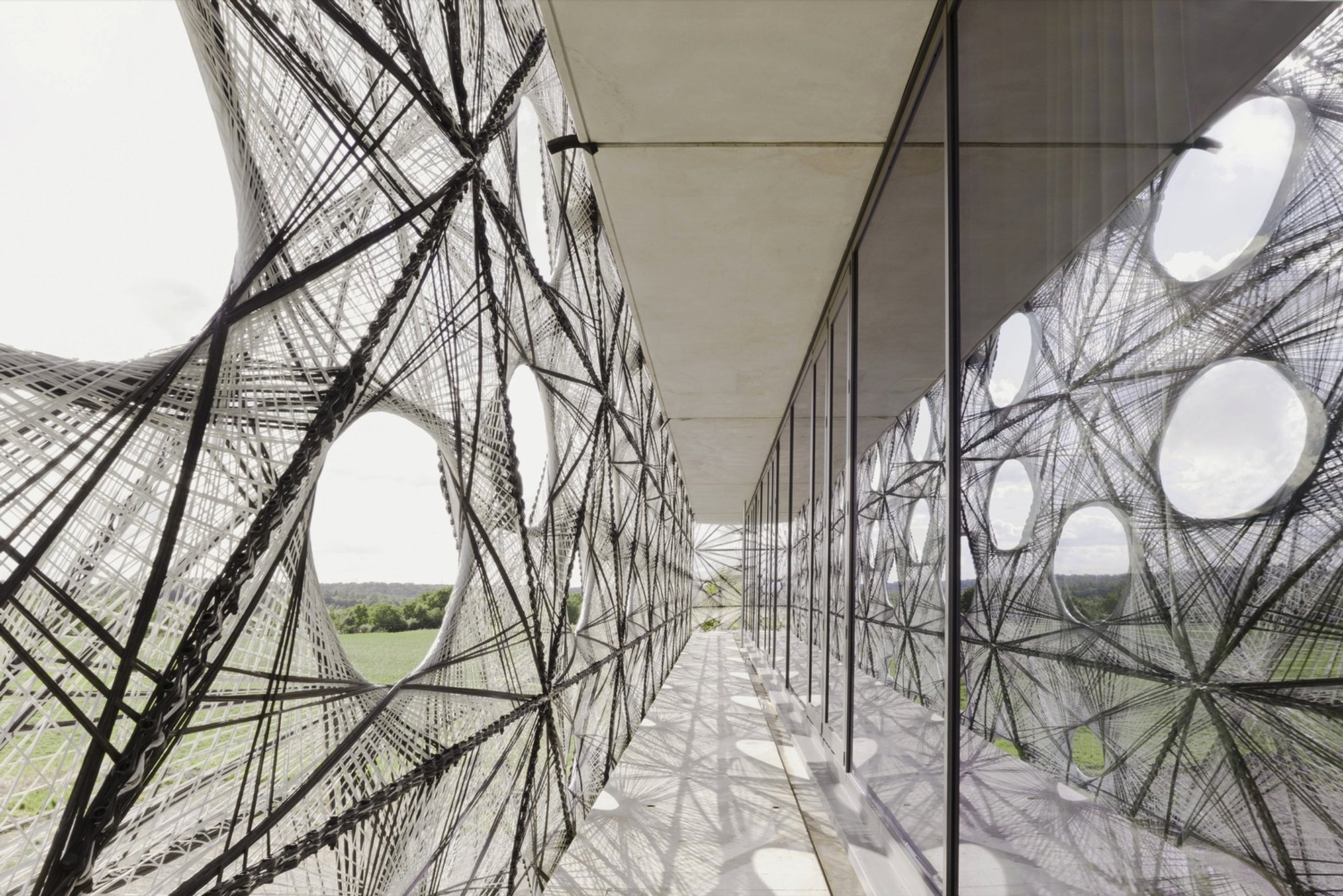 allmannwappner and Menges Scheffler Wrap a University Building in Robotically Woven Fiber Tiles