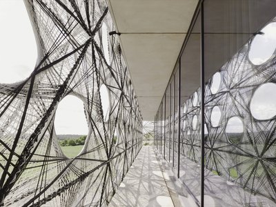allmannwappner and Menges Scheffler Wrap a University Building in Robotically Woven Fiber Tiles