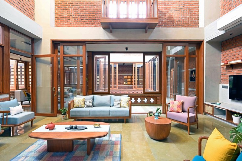 Living area opening onto central courtyard through timber-framed folding glass doors and clerestory windows