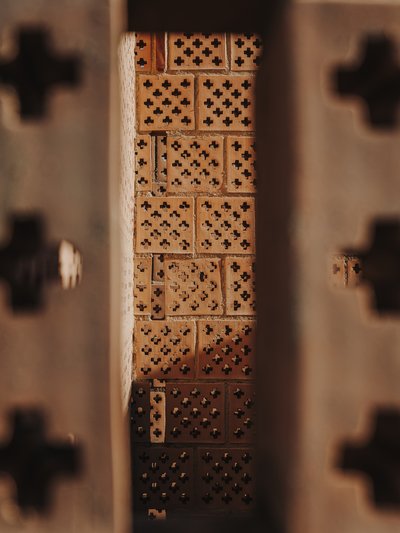 This architectural image showcases a brick wall with a distinctive lattice pattern. The bricks are a