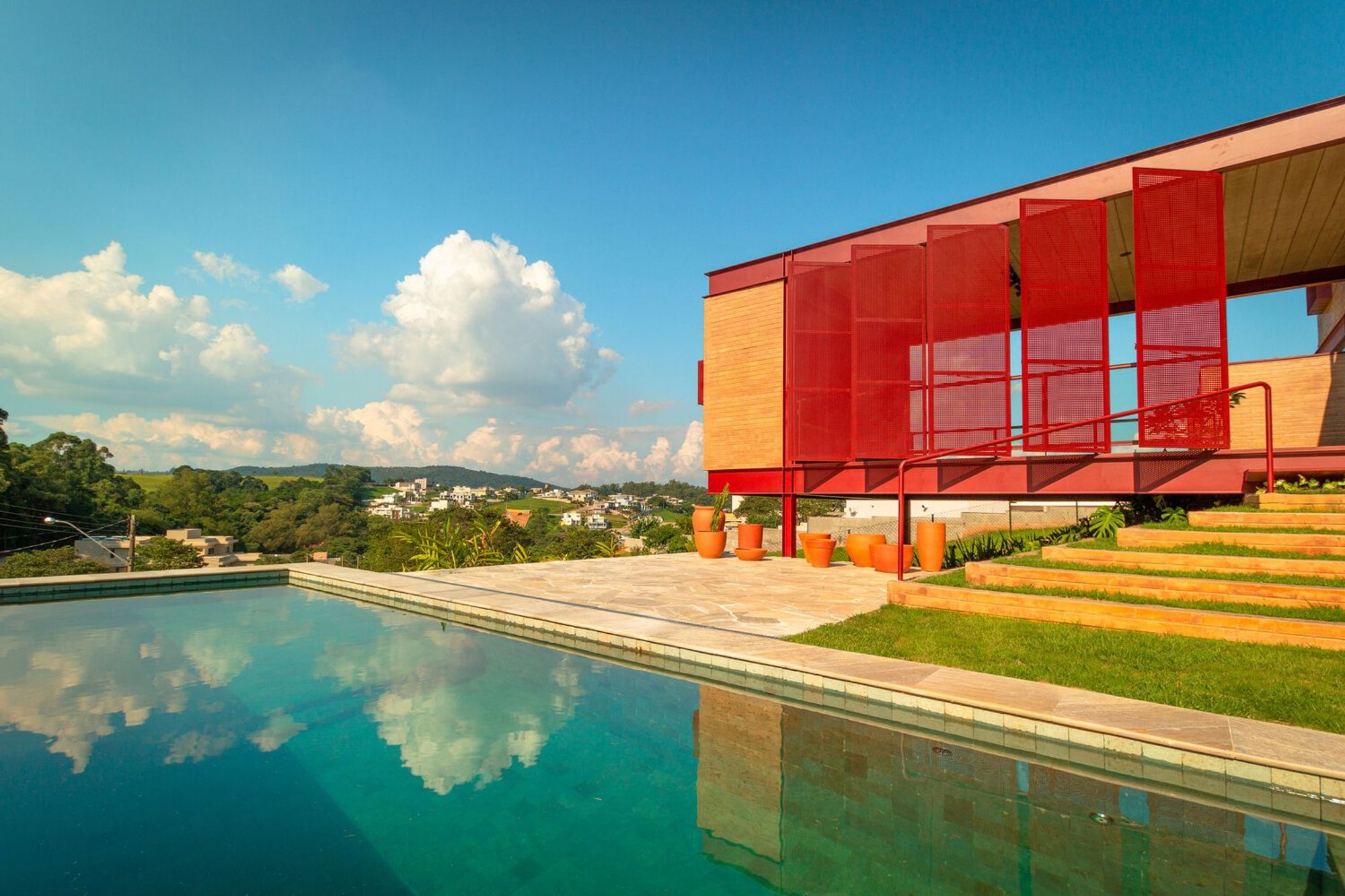 24 7 Arquitetura Crowns an Itatiba Hilltop with a Red Steel and Recycled Brick Residence