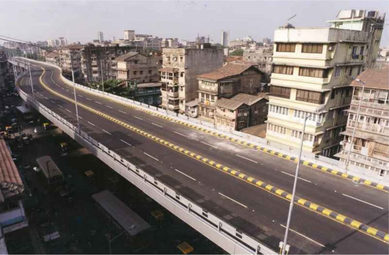 Elevated roadway cutting through a dense neighborhood in Mumbai.