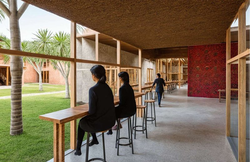 Open verandas connect interior and exterior spaces, fostering interaction while embracing the warmth of natural materials.