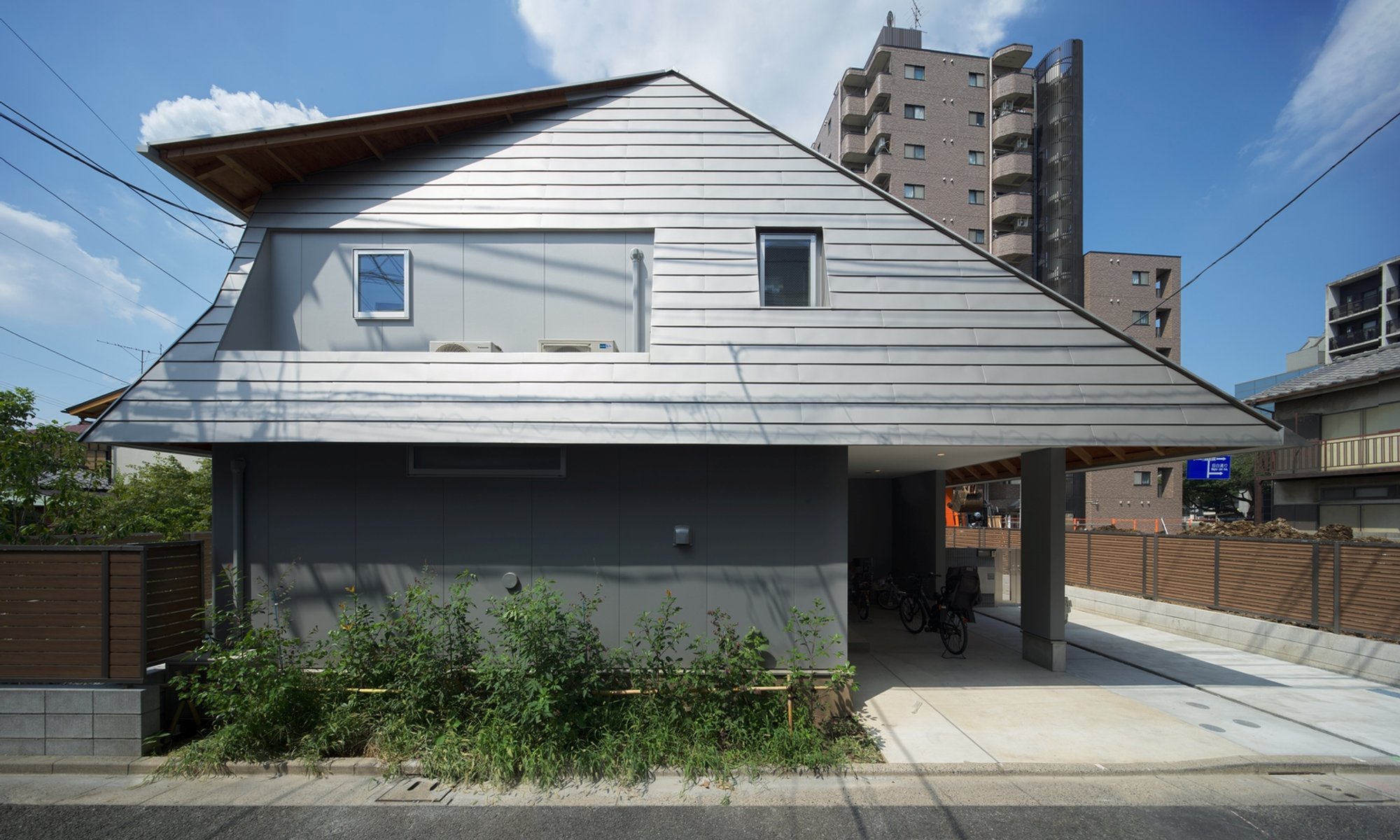 Two Large Roofs Leaning Together by KOMINORU Design