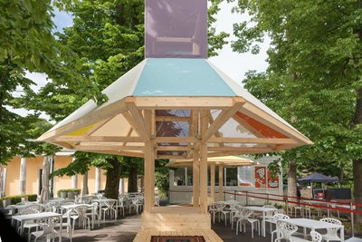 This architectural image showcases a contemporary pavilion with a wooden frame and geometric design.