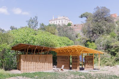 This architectural image showcases a sustainable design featuring earthen walls and a wooden structu