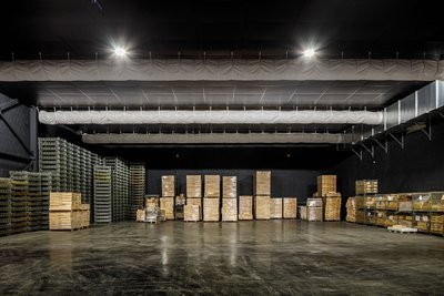 This architectural image showcases the interior of a large warehouse, characterized by its high ceil