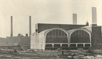 This is a vintage monochrome photograph of an industrial building, likely a factory, featuring a bri