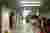 This photo depicts a long, cluttered corridor in what appears to be a storage area or warehouse. The