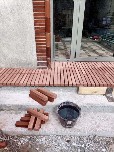 This architectural image showcases the construction of a brick threshold and facade detail. The desi