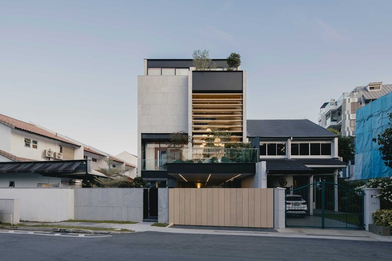 Street view of the stacked concrete and timber facade with horizontal louvered screen at dusk