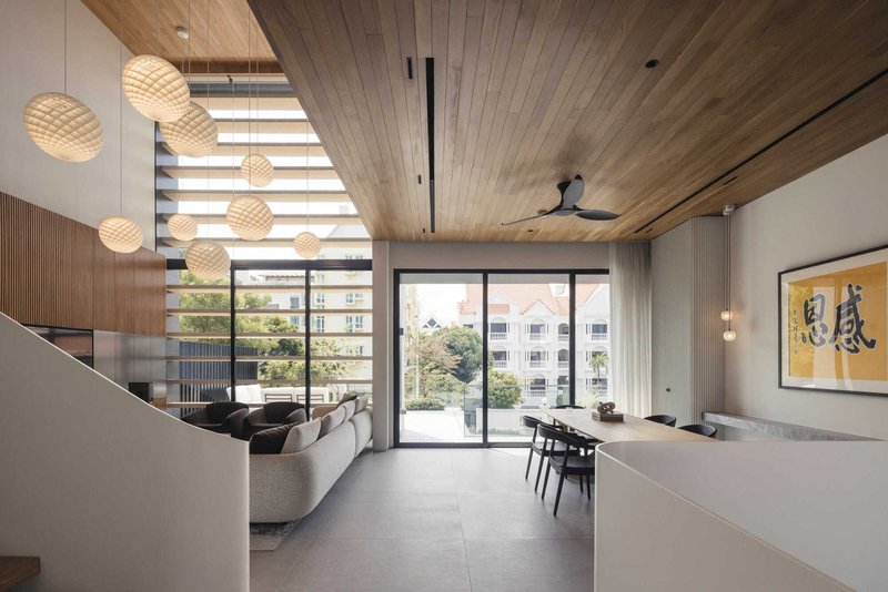 Double-height living space with timber ceiling, horizontal louvered screens and woven pendant lights