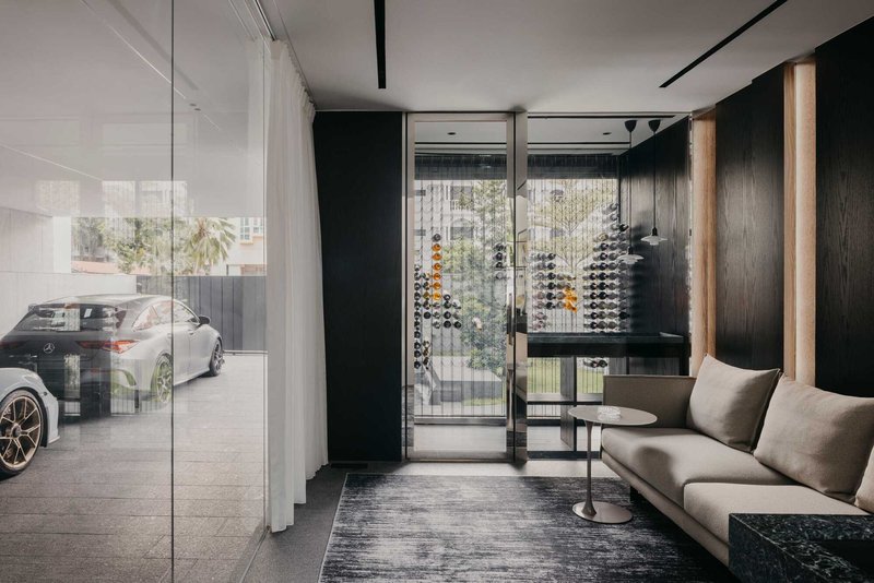Ground-floor entry with glass wall, dark timber paneling and wine bottle display behind the seating