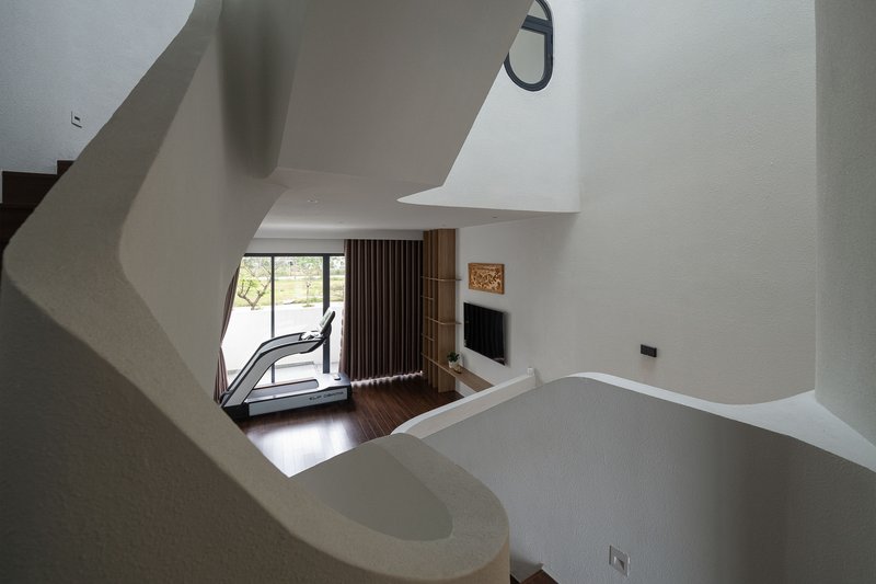 View down the curved stairwell to living space with vertical timber slat screen