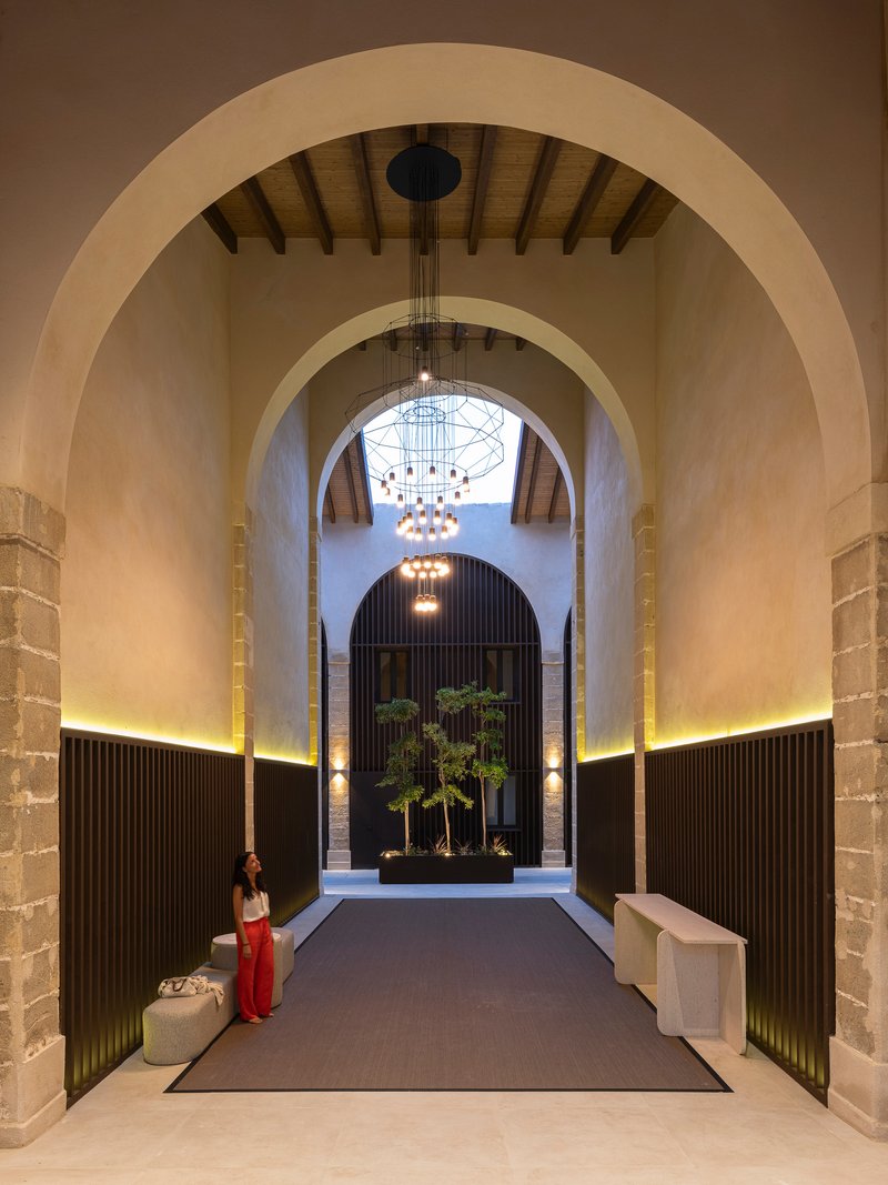 Vaulted entrance hall with tiered chandelier and a planted reflecting box