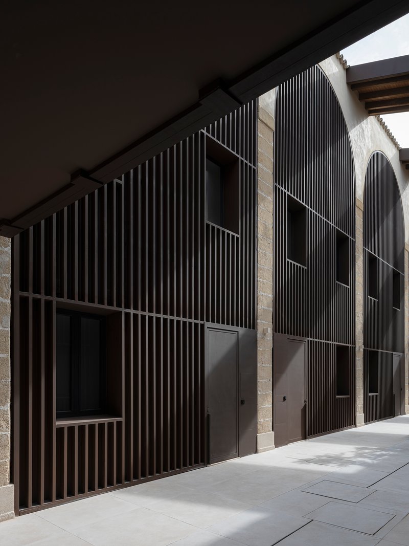 Detail of vertical timber slat screen against original sandstone walls