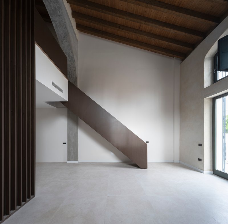 Double-height interior with original timber roof and a steel stair