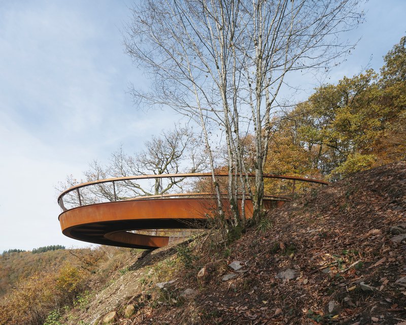 The raised tip of the curve cantilevering out over the forest slope
