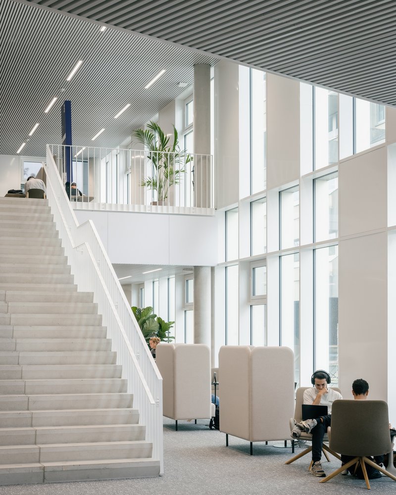 White feature stair rising through the double-height entrance hall