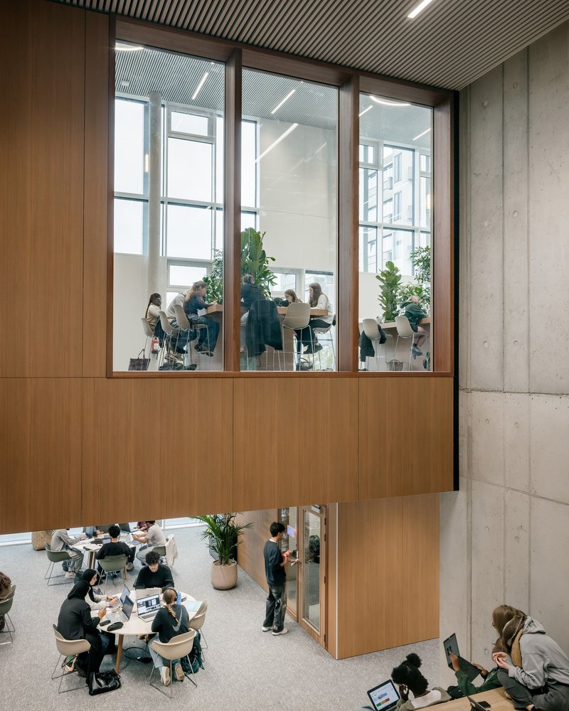 View up to a timber-framed seminar room above an open study lounge