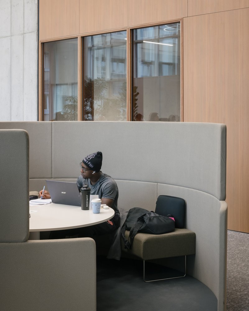 Acoustic study booth with curved upholstered walls and a small round table