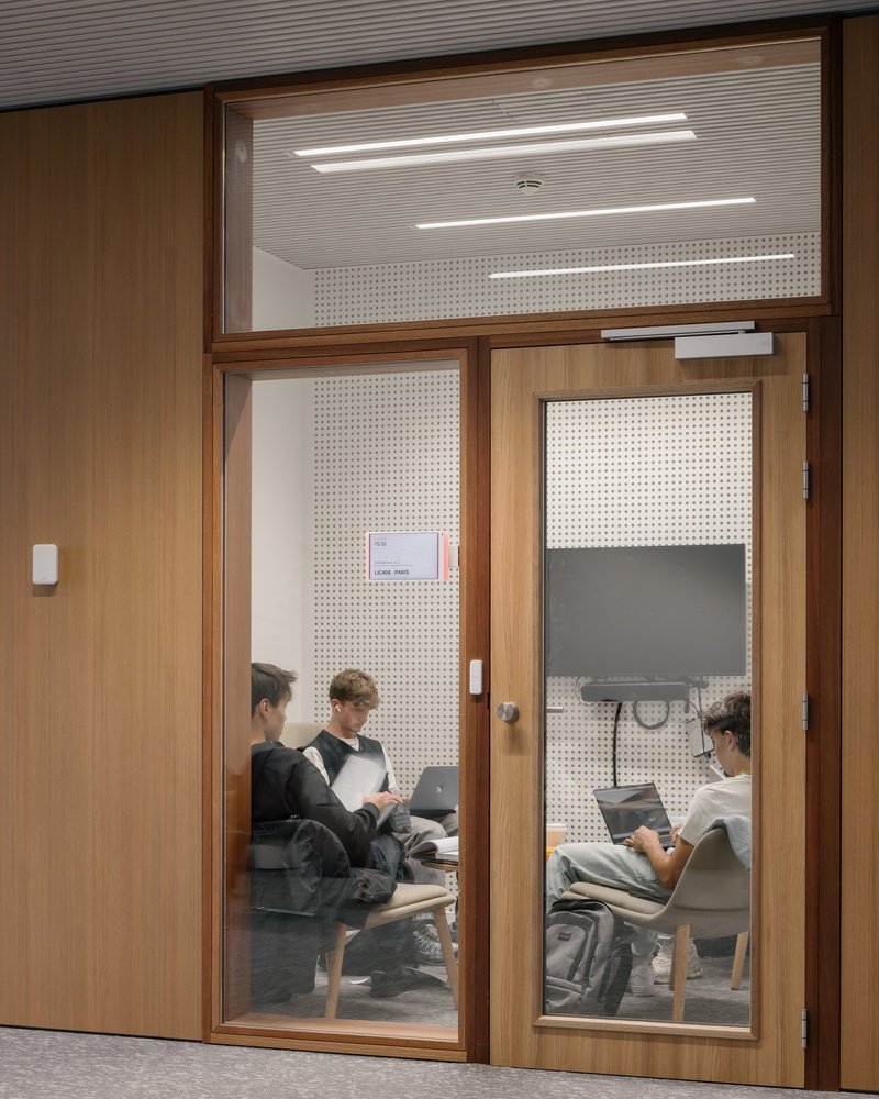 Glass-fronted group study room with timber framing and an interior screen