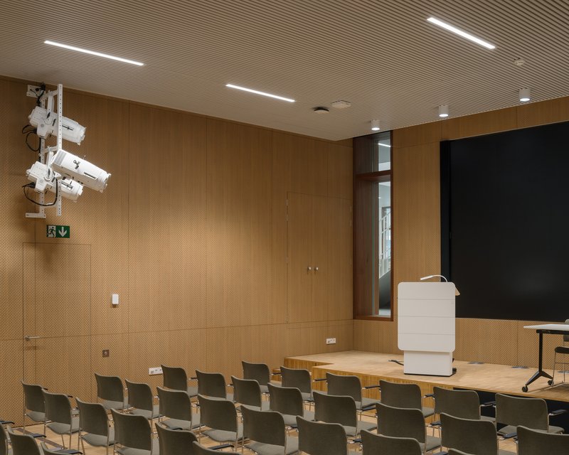 Auditorium with timber-panelled walls and tiered seating